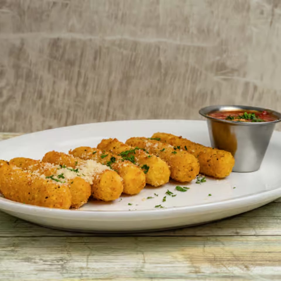 Golden-brown mozzarella sticks, sprinkled with Parmesan and parsley, served with a side of marinara sauce.