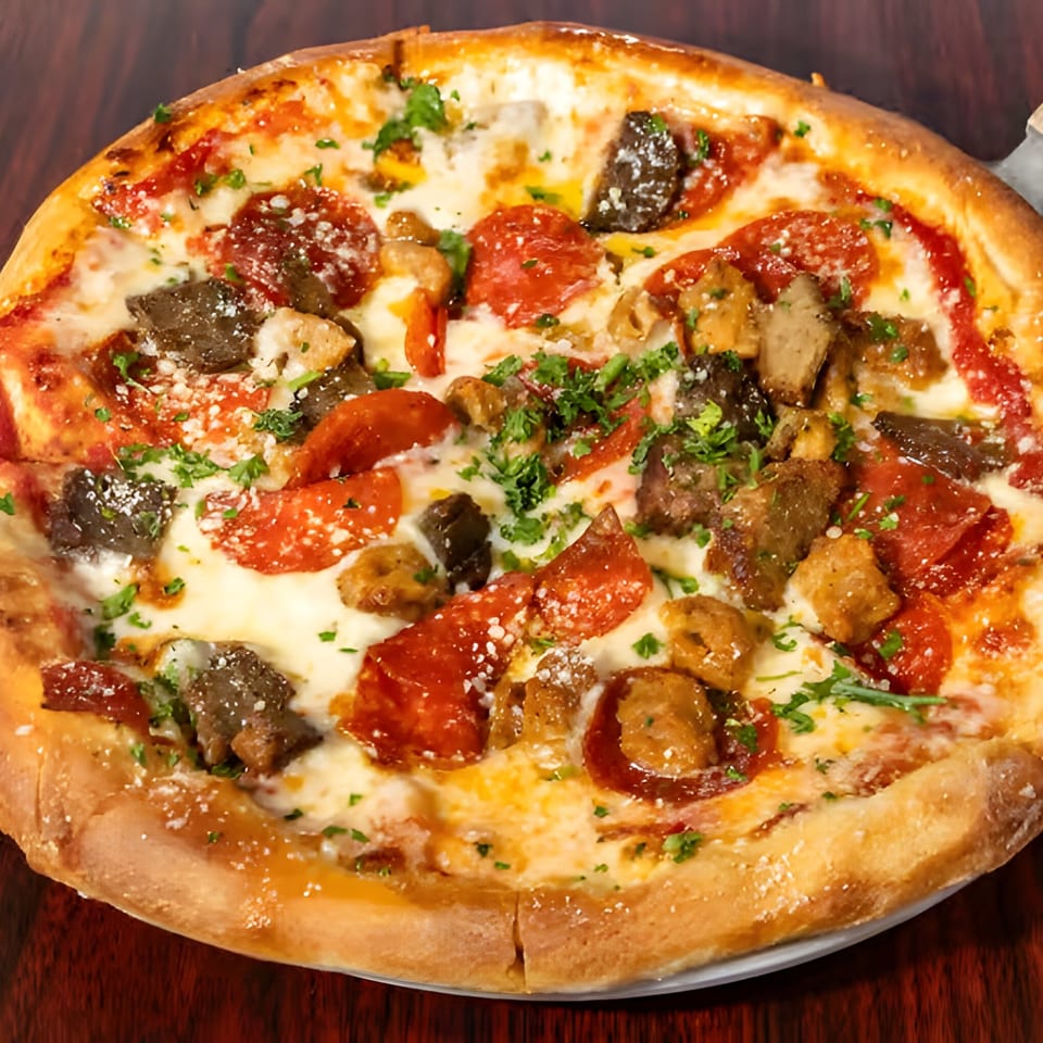 A close-up of a freshly baked Italian pizza with pepperoni, sausage, and mushrooms.
